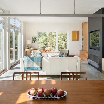 Example of a mid-sized danish open concept concrete floor living room design in Portland Maine with white walls, a ribbon fireplace, a concrete fireplace and a media wall