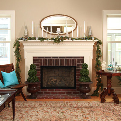 Inspiration for a country medium tone wood floor living room remodel in Minneapolis with beige walls, a standard fireplace and a brick fireplace