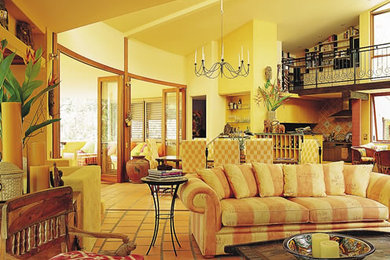 Foto di un ampio soggiorno boho chic aperto con pareti gialle e pavimento in terracotta