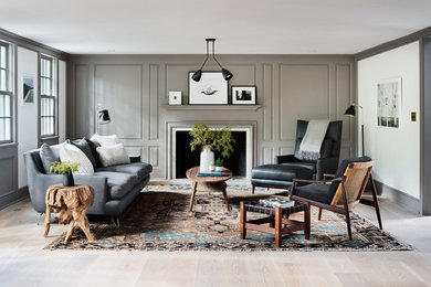 Country light wood floor living room photo in New York with white walls, a standard fireplace and a wood fireplace surround