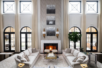 Immagine di un ampio soggiorno minimalista aperto con pareti grigie, parquet scuro e camino classico