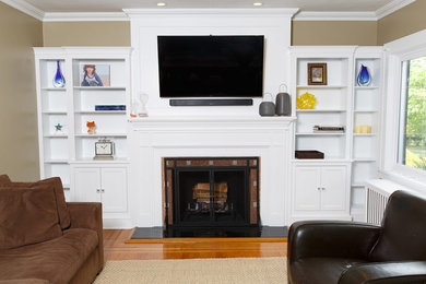 Example of a mid-sized transitional enclosed medium tone wood floor living room library design in New York with beige walls, a standard fireplace, a tile fireplace and a wall-mounted tv