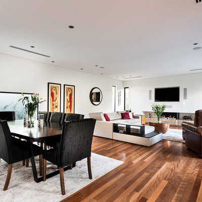 Example of a large trendy open concept medium tone wood floor living room design in Perth with white walls, a ribbon fireplace and a wall-mounted tv