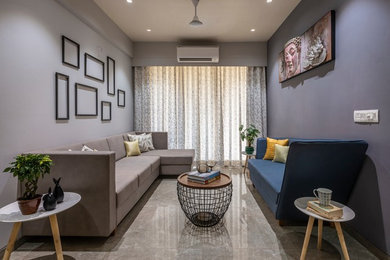 アフマダーバードにあるおしゃれな独立型リビング (グレーの壁、グレーの床、青いソファ) の写真