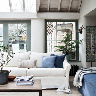 Inspiration for a mediterranean living room in Wiltshire with white walls, light hardwood flooring and beige floors.