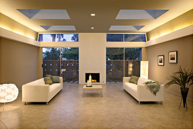 This is an example of a large midcentury open plan living room in Orange County with beige walls, porcelain flooring, a standard fireplace and a tiled fireplace surround.