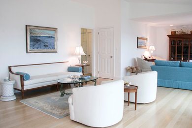 Cette photo montre un salon moderne de taille moyenne et ouvert avec une salle de réception, un mur blanc, parquet clair et un téléviseur dissimulé.