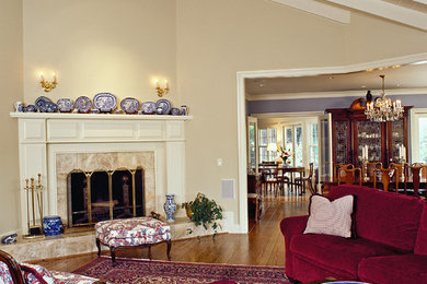 Klassisk inredning av ett vardagsrum, med beige väggar och en öppen hörnspis