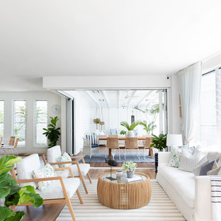 Expansive beach style open concept living room in Gold Coast - Tweed with white walls, brown floor, vinyl floors and no tv.
