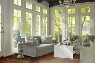 Imagen de salón para visitas abierto grande con paredes grises, suelo de madera en tonos medios y suelo marrón