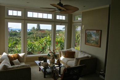 This is an example of a large open plan living room in Hawaii with beige walls and carpet.