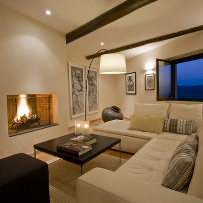 Inspiration for a mediterranean living room remodel in Marseille with beige walls and a standard fireplace