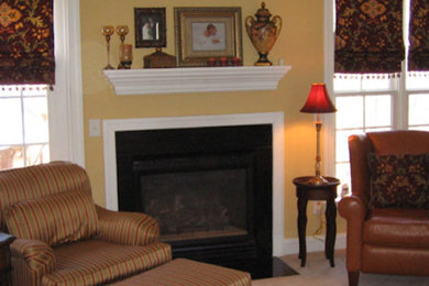 Example of a mid-sized living room design in Raleigh with yellow walls, a standard fireplace and no tv