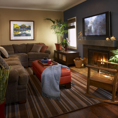 Living room - medium tone wood floor living room idea in San Francisco with beige walls, a standard fireplace and a wall-mounted tv
