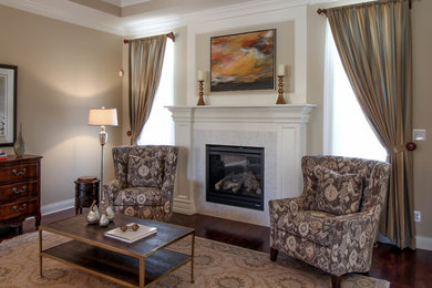 Mittelgroßes, Fernseherloses, Offenes Klassisches Wohnzimmer mit beiger Wandfarbe, dunklem Holzboden, Kamin und Kaminumrandung aus Stein in Indianapolis