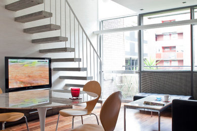 Imagen de salón tipo loft moderno de tamaño medio sin chimenea con paredes blancas, suelo de madera en tonos medios y televisor independiente