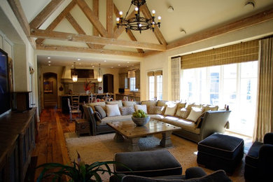 Diseño de salón abierto tradicional de tamaño medio con paredes beige, suelo de madera en tonos medios y suelo marrón