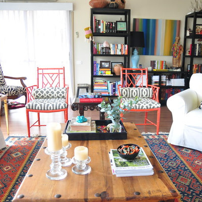 Inspiration for a large eclectic formal and open concept medium tone wood floor and brown floor living room remodel in Austin with beige walls, no fireplace and a concealed tv