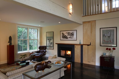 Example of a mid-sized trendy open concept concrete floor living room design in Portland Maine with beige walls, a standard fireplace, a stone fireplace and a concealed tv