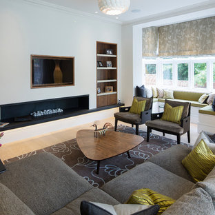Contemporary formal living room in London with white walls, light hardwood flooring, a ribbon fireplace and a wall mounted tv.
