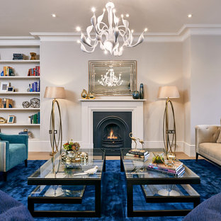 Contemporary living room in London with grey walls, medium hardwood flooring, a standard fireplace and brown floors.
