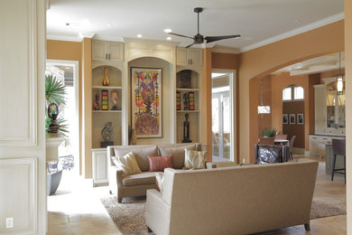 На фото: большая открытая, парадная гостиная комната в средиземноморском стиле с оранжевыми стенами, стандартным камином, фасадом камина из дерева и полом из травертина