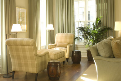 Modelo de salón para visitas abierto clásico de tamaño medio sin televisor con paredes blancas y suelo de madera en tonos medios