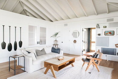 Example of a mid-sized beach style formal and enclosed medium tone wood floor and brown floor living room design in Los Angeles with white walls, no fireplace and no tv