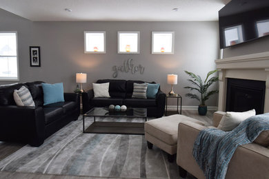 Example of a transitional vinyl floor and gray floor living room design in Minneapolis with gray walls, a standard fireplace, a wood fireplace surround and a wall-mounted tv