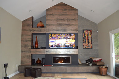 サンフランシスコにある高級な中くらいなコンテンポラリースタイルのおしゃれなリビング (ベージュの壁、淡色無垢フローリング、標準型暖炉、金属の暖炉まわり、壁掛け型テレビ、ベージュの床) の写真