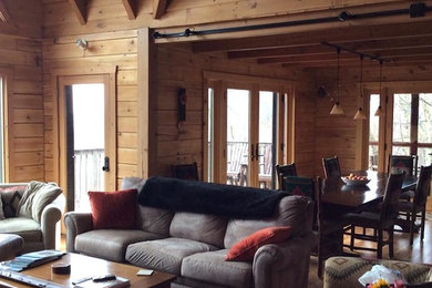 Immagine di un soggiorno american style di medie dimensioni e aperto con pareti marroni e parquet chiaro