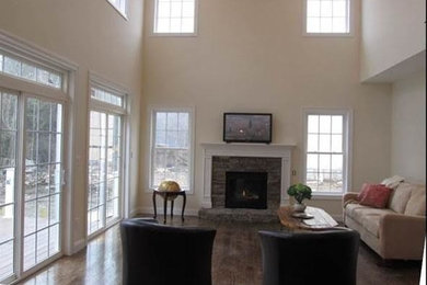 Inspiration for a large formal open plan living room in Boston with beige walls, dark hardwood flooring, a standard fireplace, a stone fireplace surround and a wall mounted tv.