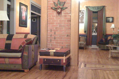 Modelo de salón ecléctico con paredes marrones y suelo de madera clara