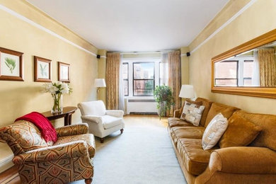 ニューヨークにある低価格の広いトラディショナルスタイルのおしゃれなリビング (ベージュの壁、無垢フローリング、暖炉なし、内蔵型テレビ、グレーの床) の写真