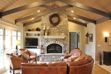 Inspiration for a mid-sized timeless open concept medium tone wood floor living room remodel in Seattle with beige walls, a standard fireplace, a stone fireplace and a media wall