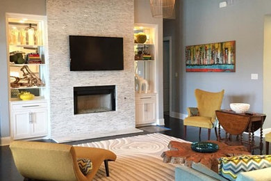 Свежая идея для дизайна: большая открытая гостиная комната в современном стиле с серыми стенами, темным паркетным полом, стандартным камином, фасадом камина из камня и телевизором на стене - отличное фото интерьера