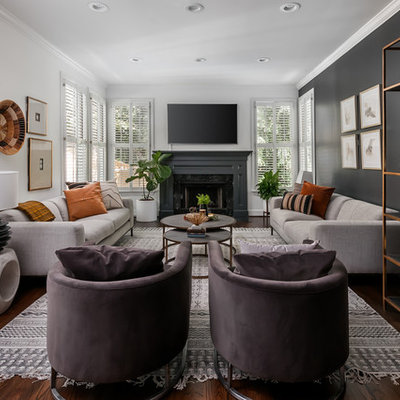 Example of a mid-sized transitional open concept dark wood floor and brown floor living room design in Atlanta with black walls, a standard fireplace, a stone fireplace and a wall-mounted tv