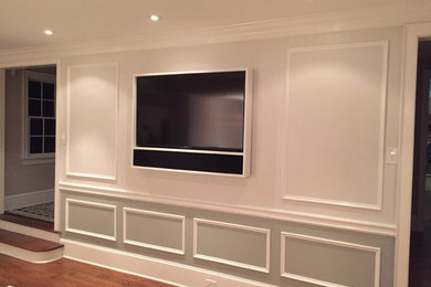 Example of a mid-sized trendy open concept medium tone wood floor living room design in Philadelphia with white walls, a wall-mounted tv and no fireplace