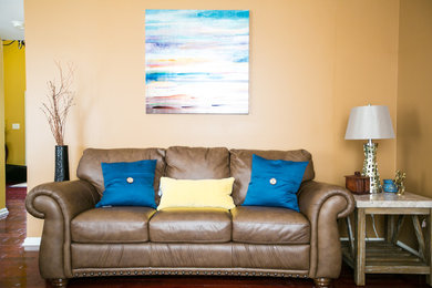 Ejemplo de salón cerrado tradicional de tamaño medio con paredes amarillas y televisor colgado en la pared