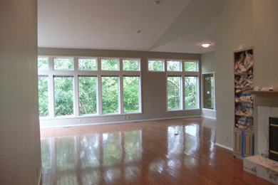 Example of a light wood floor living room design in Other with green walls
