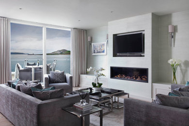 Living room with contemporary fireplace, seagrass wallpaper, custom made sofa an