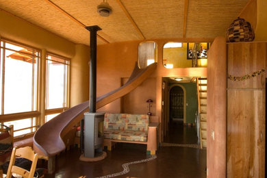Ejemplo de salón abierto ecléctico pequeño sin televisor con parades naranjas, estufa de leña y suelo marrón