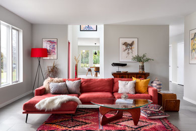 ニューヨークにある高級な広いコンテンポラリースタイルのおしゃれなLDK (グレーの床、セラミックタイルの床、グレーの壁、赤いソファ) の写真