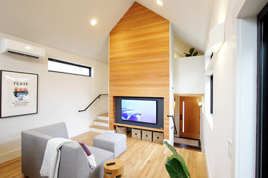 Example of a small trendy open concept light wood floor living room design in Seattle with white walls and a wall-mounted tv