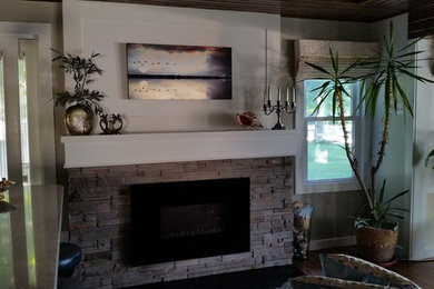 Cette image montre un salon traditionnel de taille moyenne et ouvert avec un mur beige, parquet foncé, une cheminée standard, un manteau de cheminée en pierre et un sol marron.