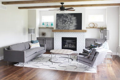 Inspiration for a mid-sized contemporary formal and open concept medium tone wood floor living room remodel in Cedar Rapids with white walls, a standard fireplace and a tile fireplace