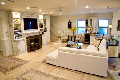 Example of a large classic open concept light wood floor living room design in Other with beige walls, a standard fireplace, a stone fireplace and a wall-mounted tv