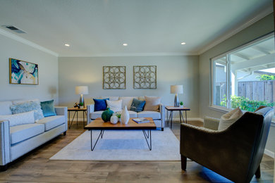 Modelo de salón abierto clásico renovado de tamaño medio sin chimenea y televisor con paredes grises, suelo de madera en tonos medios y suelo marrón