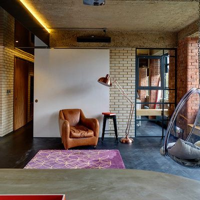 Inspiration for an industrial dark wood floor and black floor living room remodel in London with beige walls