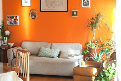 Design ideas for a medium sized eclectic formal enclosed living room in Dorset with orange walls.